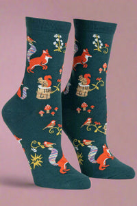 Pair of socks with fox and nature pattern on a light gray background