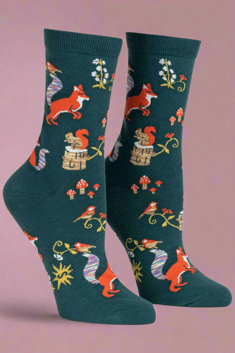 Pair of socks with fox and nature pattern on a light gray background