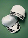 White foam trucker hat with black leaf pattern. Adjustable.