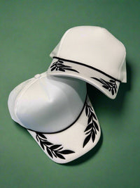 White foam trucker hat with black leaf pattern. Adjustable.