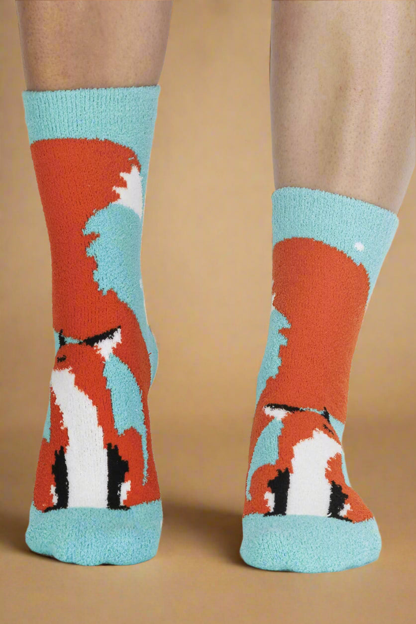 Socks with fox design worn by a person on a light gray background