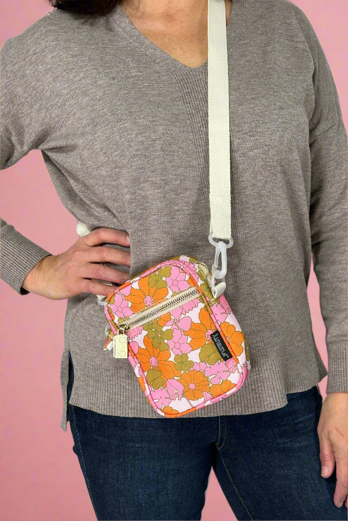 A small crossbody bag in a funky floral print. Has zipper closures.