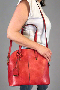 Model is carrying a large red bowler bag. 