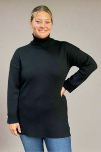 A women’s medium weight long sleeve turtle neck sweater tunic in black with gold button detail on sleeve cuffs.