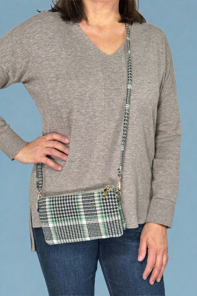 Model is wearing a small plaid crossbody bag with a removable strap.