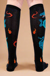 Black knee-high socks with dragon and flame patterns on a white background