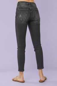Black jeans worn by a person on a gray background