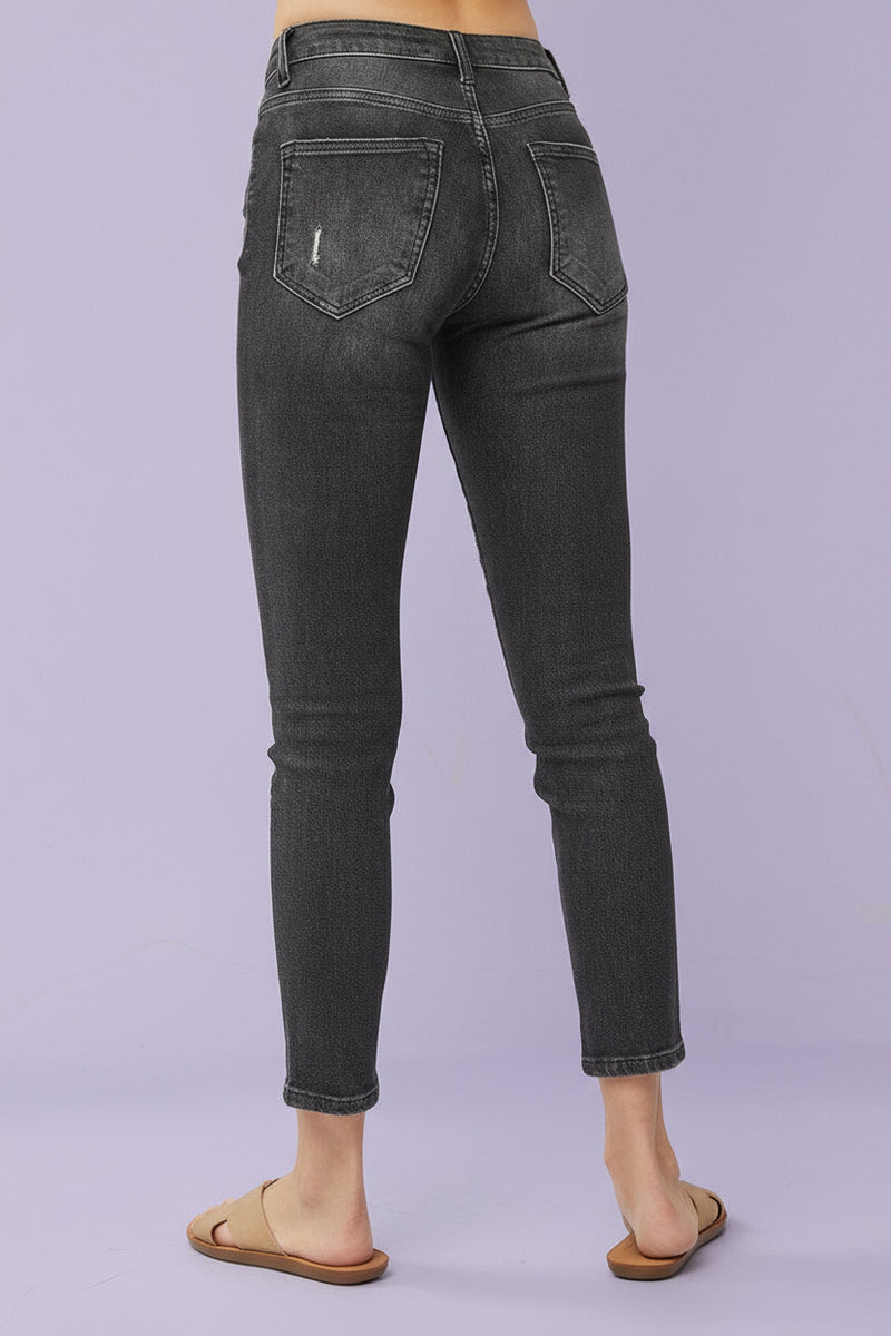 Black jeans worn by a person on a gray background