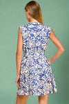 Woman wearing a blue floral dress on a plain background.