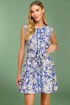 Woman wearing a blue and white floral dress on a beige background.