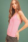 Woman wearing a pink tank top against a beige background