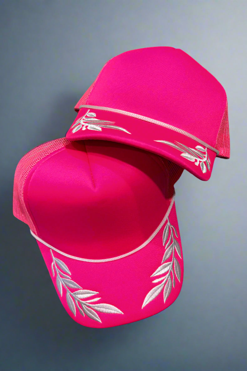 Hot pink foam trucker hat with white leaves embroidered 