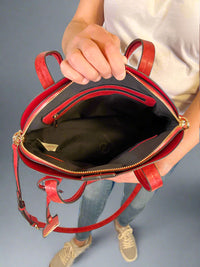 Model is carrying a large red bowler bag. 