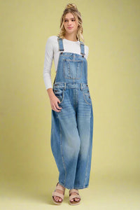 Woman wearing denim overalls on a white background