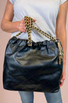 Large quilted black shoulder bag with chain strap. 
