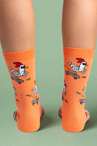 Orange socks with cartoon rooster designs on a white background