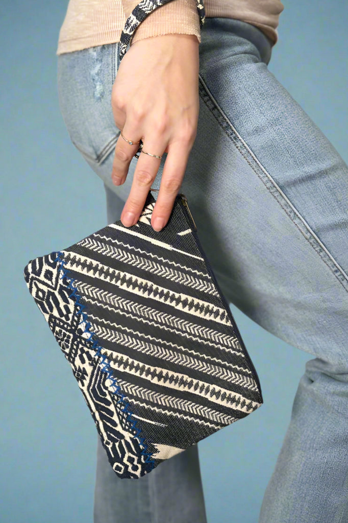 Diagonal denim printed wristlet with a detachable wrist strap.