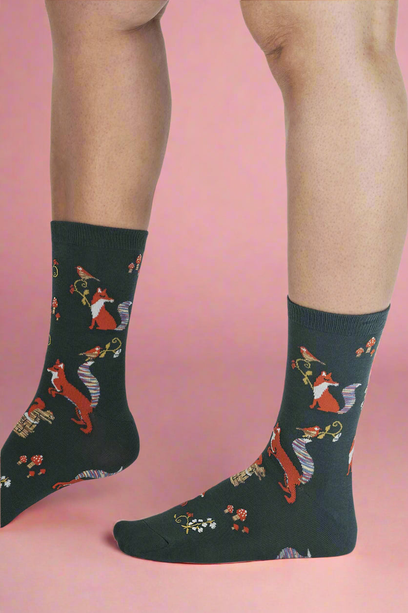 Dark blue socks with fox pattern worn by a person on a light gray background