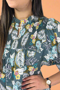 Person wearing a floral peasant top with a white background.