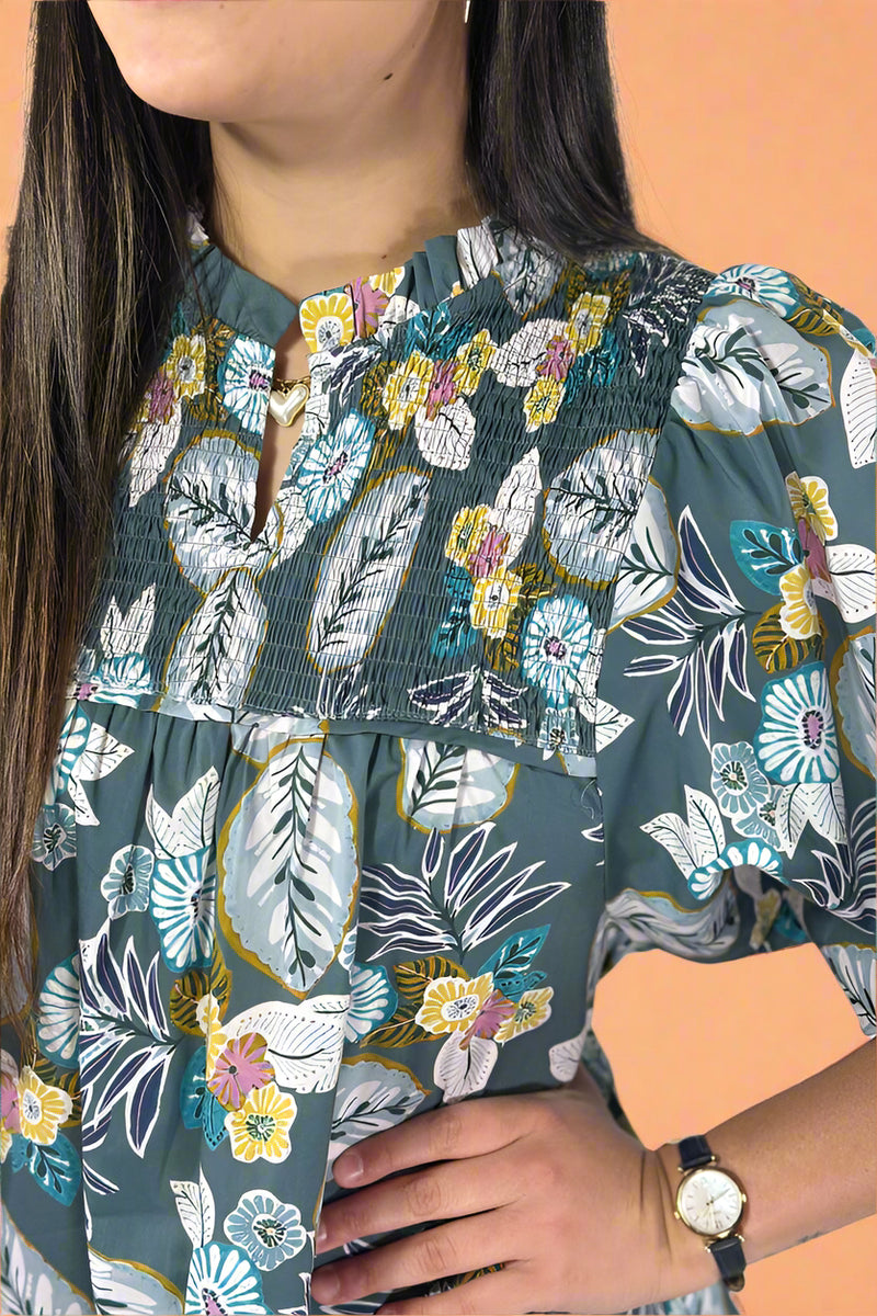 Person wearing a floral peasant top with a white background.