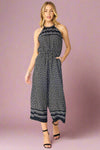 Model is wearing a cropped jumpsuit with a cute mini polka dot pattern. Jumpsuit features a halter neck line, elastic waist and front pockets. 