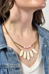 Model is wearing a fair trade necklace with bone statement pieces. 