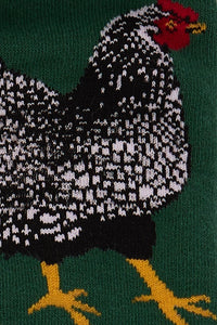 Knitted rooster design on a green background