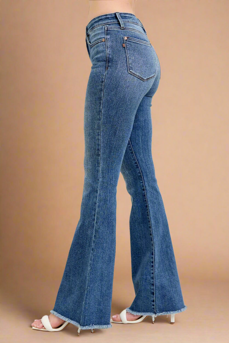 Blue jeans being worn on a plain background.