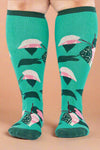 Green knee-high socks with pink and black patterns on a white background