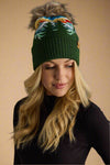 Woman wearing a green beanie with colorful design on a gray background