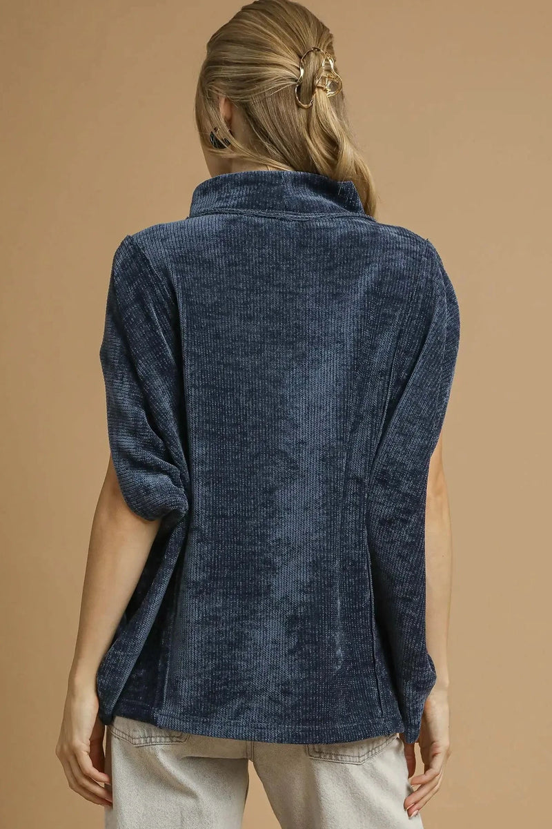 Person wearing a navy blue textured shirt against a beige background