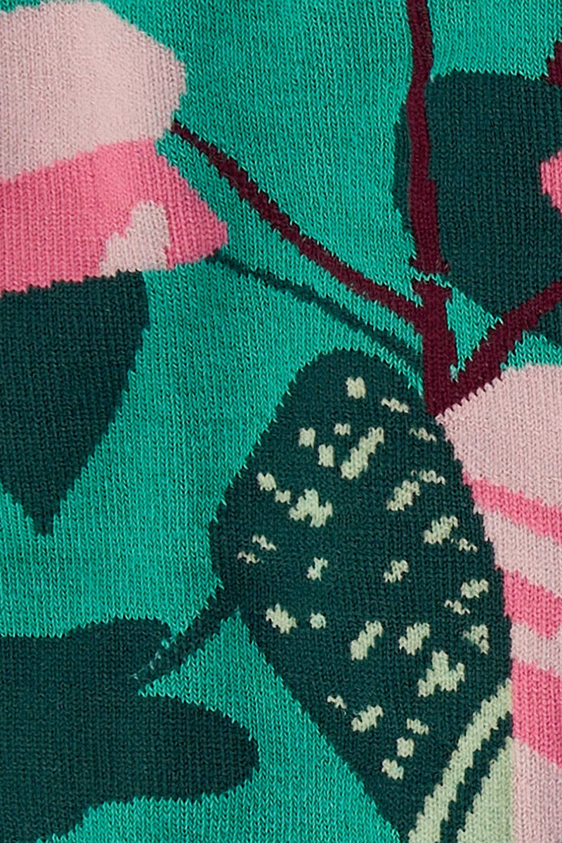 Close-up of socks with pink and green floral design on a teal background