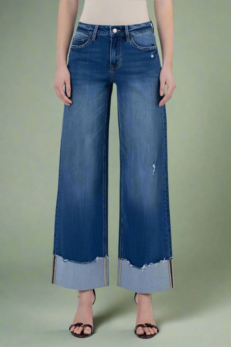Wide-leg jeans with distressed hem on a plain background.