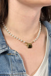Model is wear a short pearl necklace with gold heart charm. 