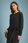 Woman wearing a black dress with a plain background