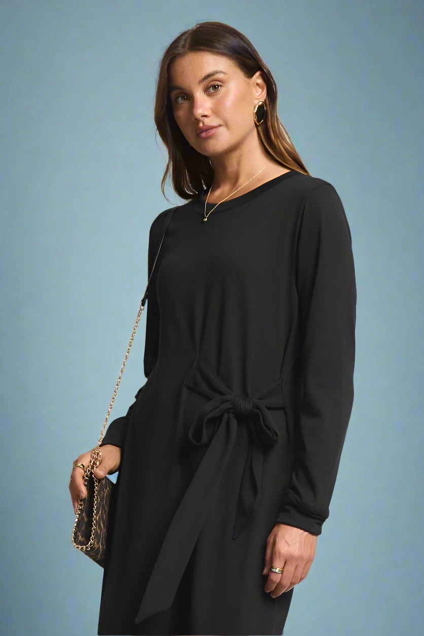 Woman wearing a black dress with a plain background