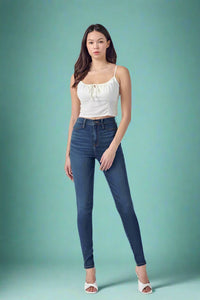 Woman wearing a white top and blue jeans on a white background