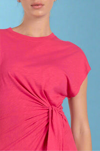 Close-up of a person wearing a bright pink top with a knot detail on a white background