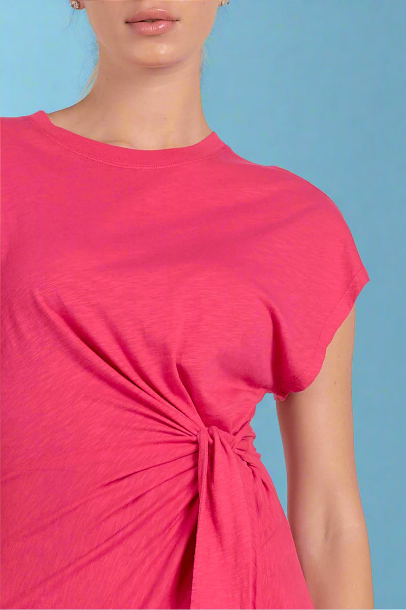 Close-up of a person wearing a bright pink top with a knot detail on a white background