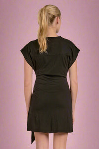 Woman wearing a black dress with a plain background