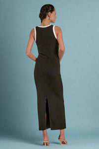 Woman wearing a black sleeveless dress with a slit on a white background
