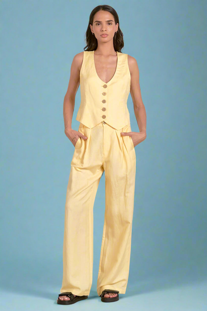 Woman wearing a yellow jumpsuit against a blue background