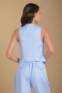 Woman wearing a light blue sleeveless top and pants set on a white background