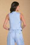 Woman wearing a light blue sleeveless top and pants set on a white background