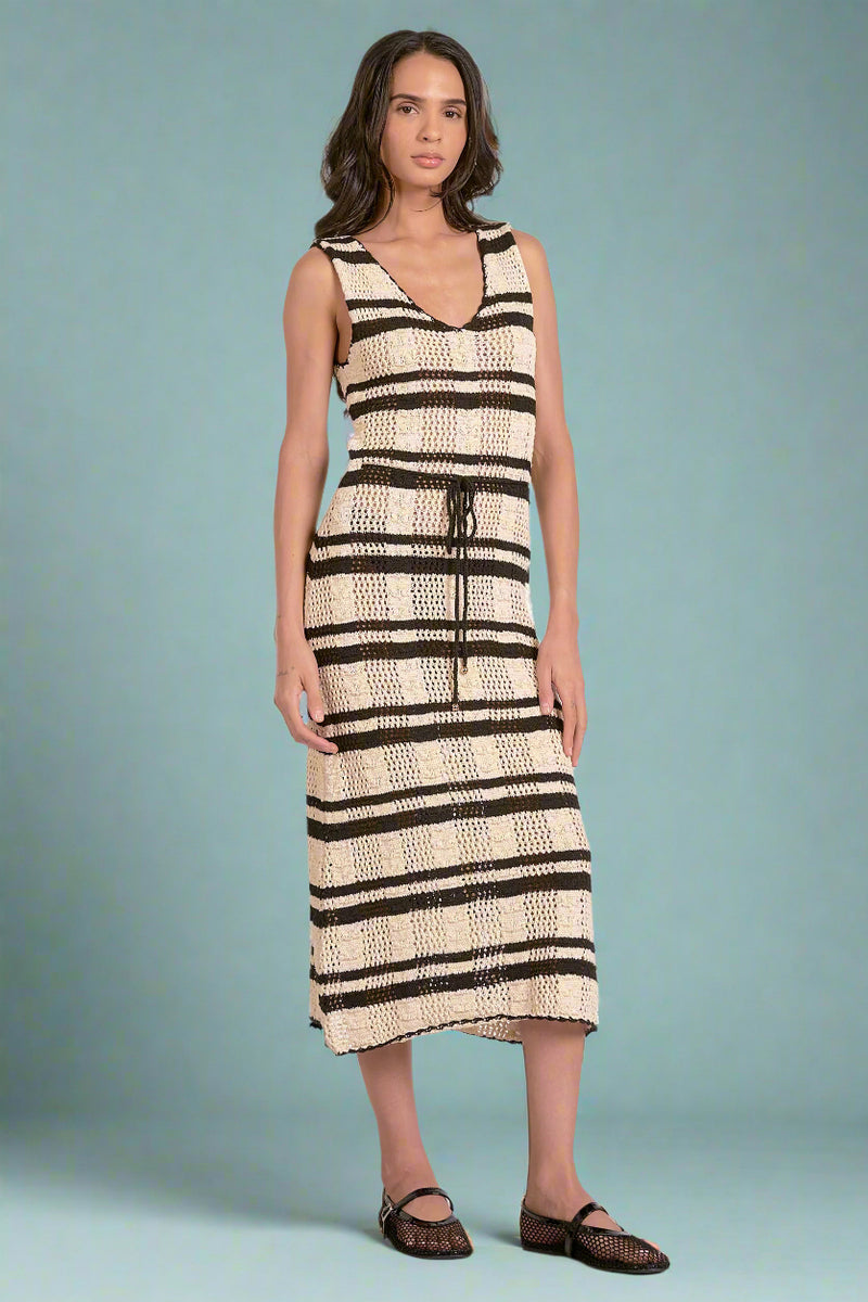 Woman wearing a black and white knit striped dress on a white background