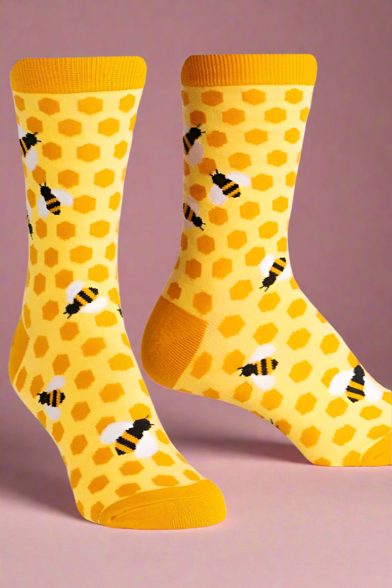 Yellow socks with honeycomb and bee pattern on a white background