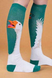 Knee-high socks with goose design on a plain background