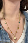 Model is wearing a gold necklace with varied celestial charms. 