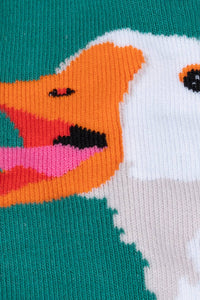 Close-up of a colorful duck design on a sock with a teal background.
