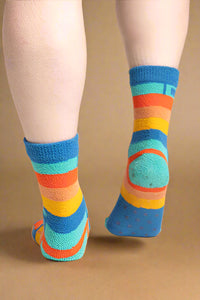 Colorful striped socks worn by a person on a plain background